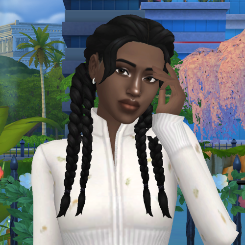A female Sim wearing Sims 4 CC braided hair poses in a park. She has long, double braided pigtails and short face framing pieces on the sides.
