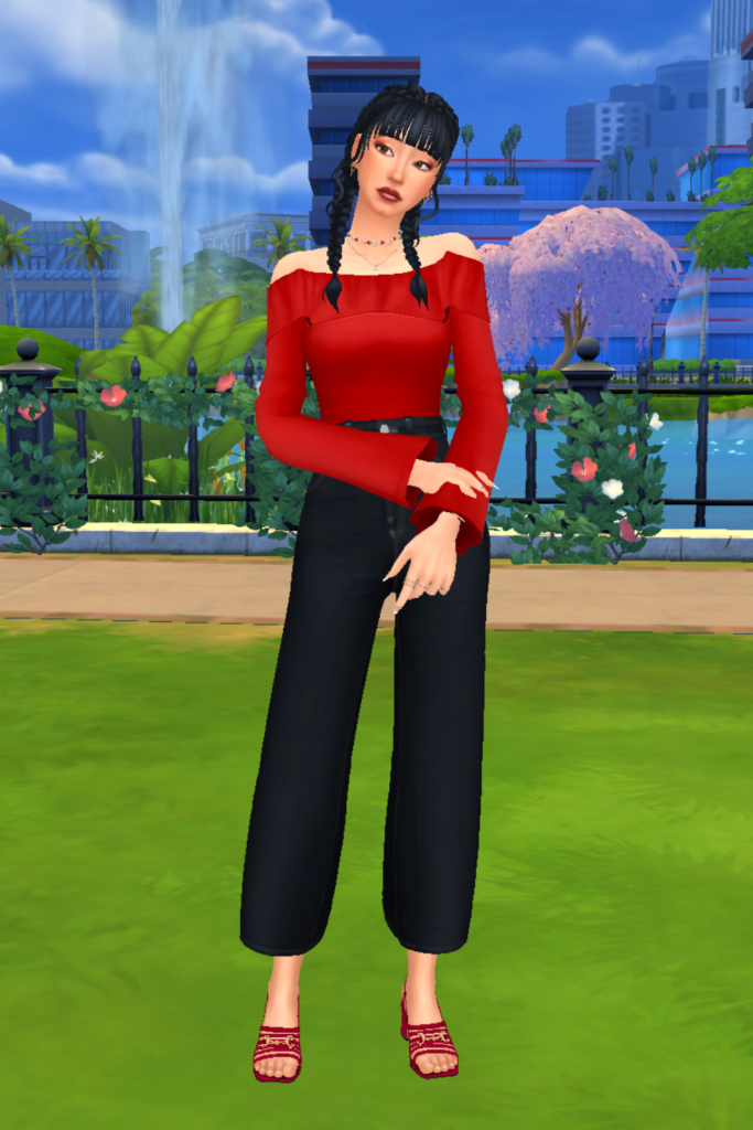 A female Sim wearing a Sims 4 CC outfit stands in a park. She is dressed in a deep red off the shoulder top and a pair of high-waisted dark-wash blue straight leg jeans. She has a pair of red strappy sandal heels on.