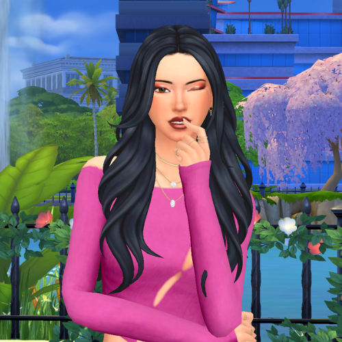 A female Sim wearing Sims 4 CC wavy long hair poses in a park. She has a wavy layered hairstyle, with face framing pieces.